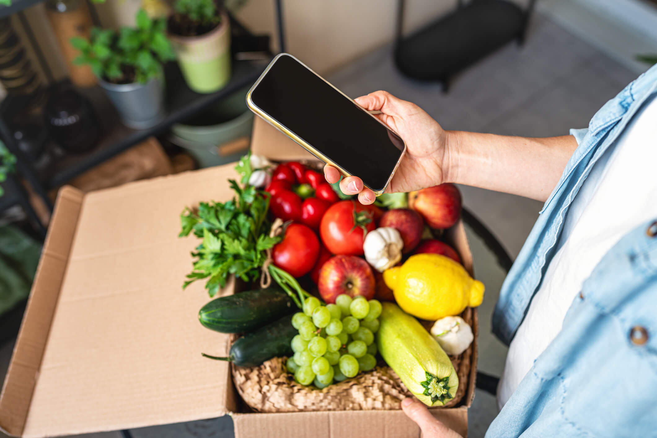 Person holding phone over produce